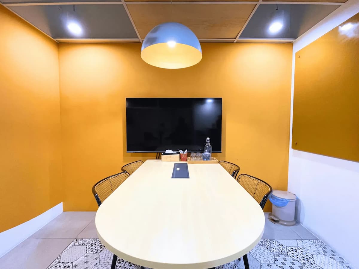 affordable discussion room with mustard yellow walls large television screen and patterned tile floor in kuala lumpur