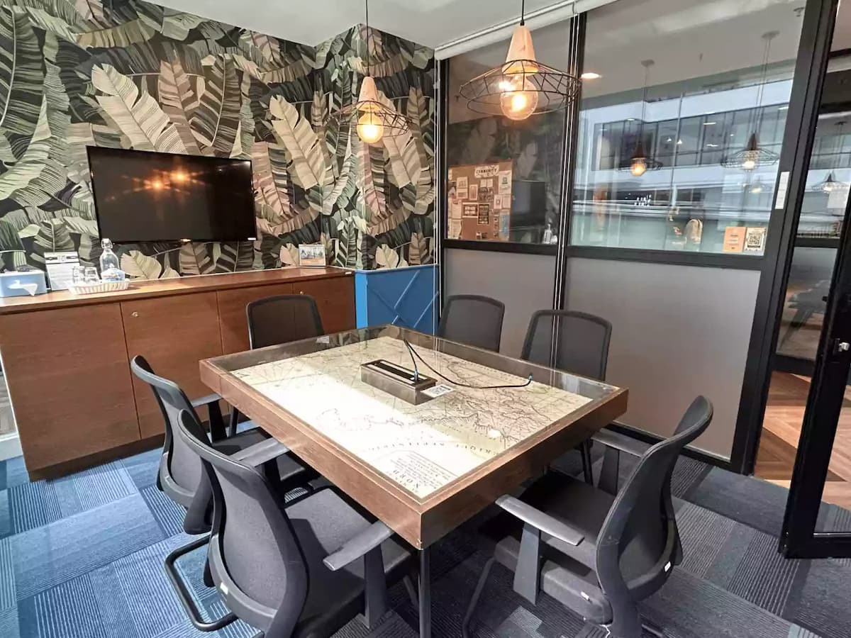 small meeting room with world map table tv screen and tropical wallpaper at event space in subang selangor