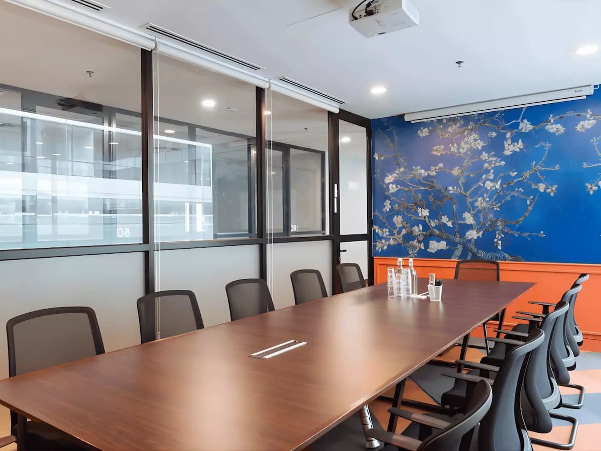 long boardroom table with twelve chairs and blue blossom mural at business meeting venue in subang selangor