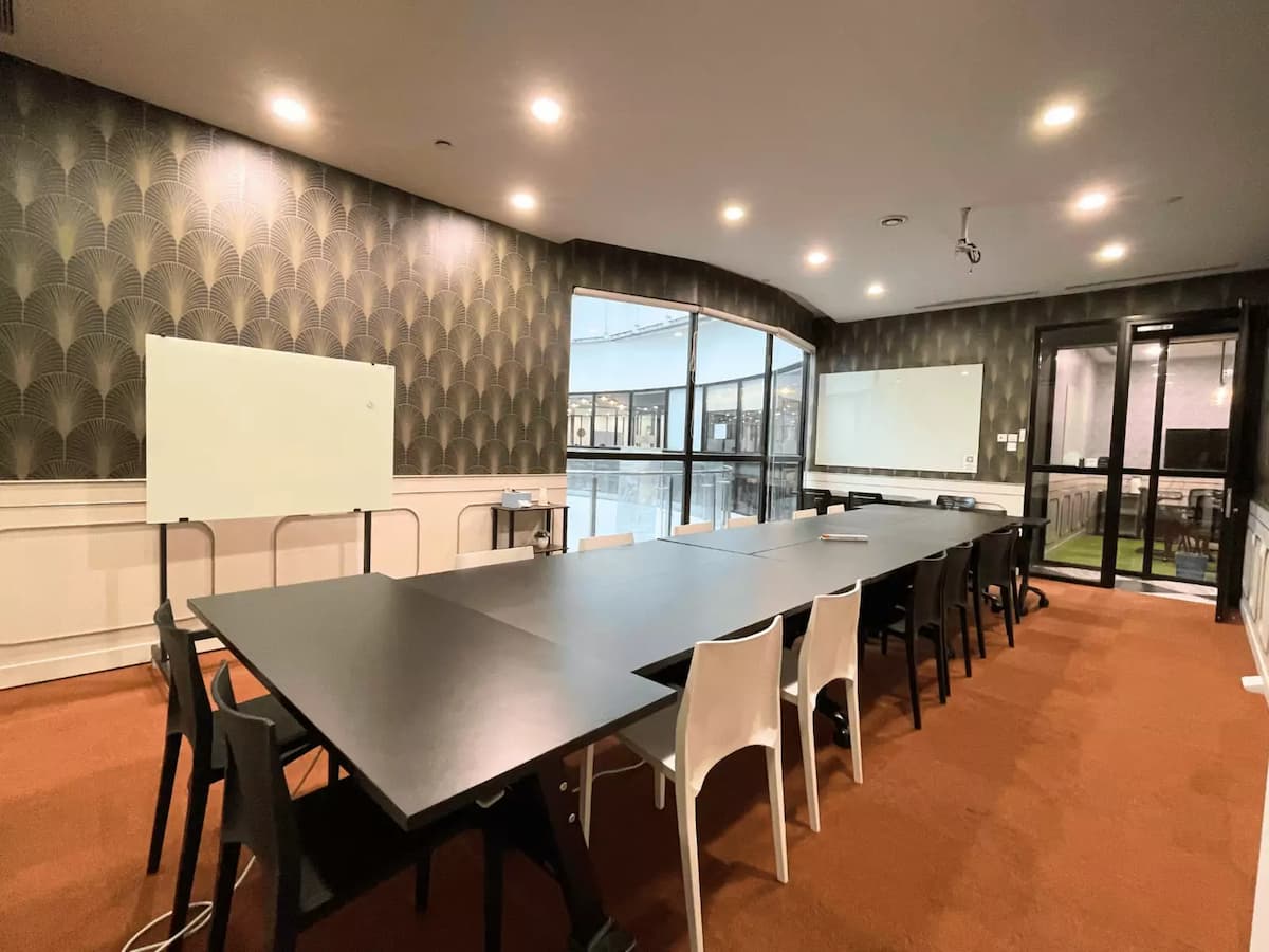long training room with rows of tables and chairs two whiteboards and large windows at a workshop event space in bangsar south kuala lumpur