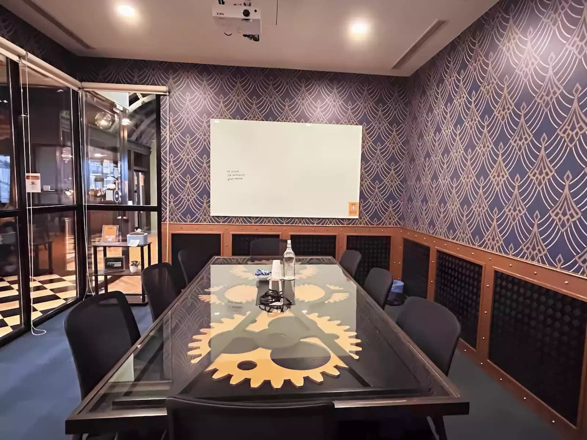 conference room with ceiling projector white presentation board and ten chairs around a patterned glass table at a workshop space in bangsar south kuala lumpur