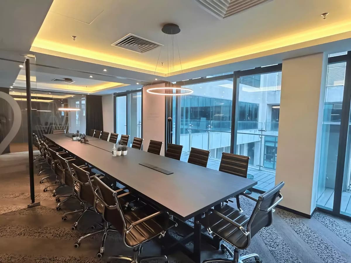 long boardroom table with leather chairs and floor to ceiling windows at a professional meeting executive room near klcc kuala lumpur