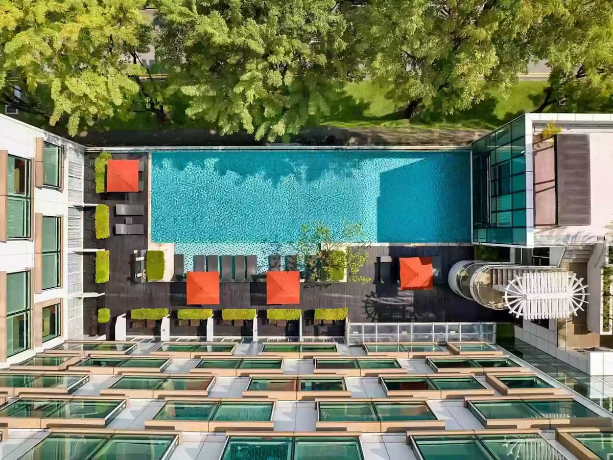 Aerial view of infinity pool with sun loungers and umbrellas.