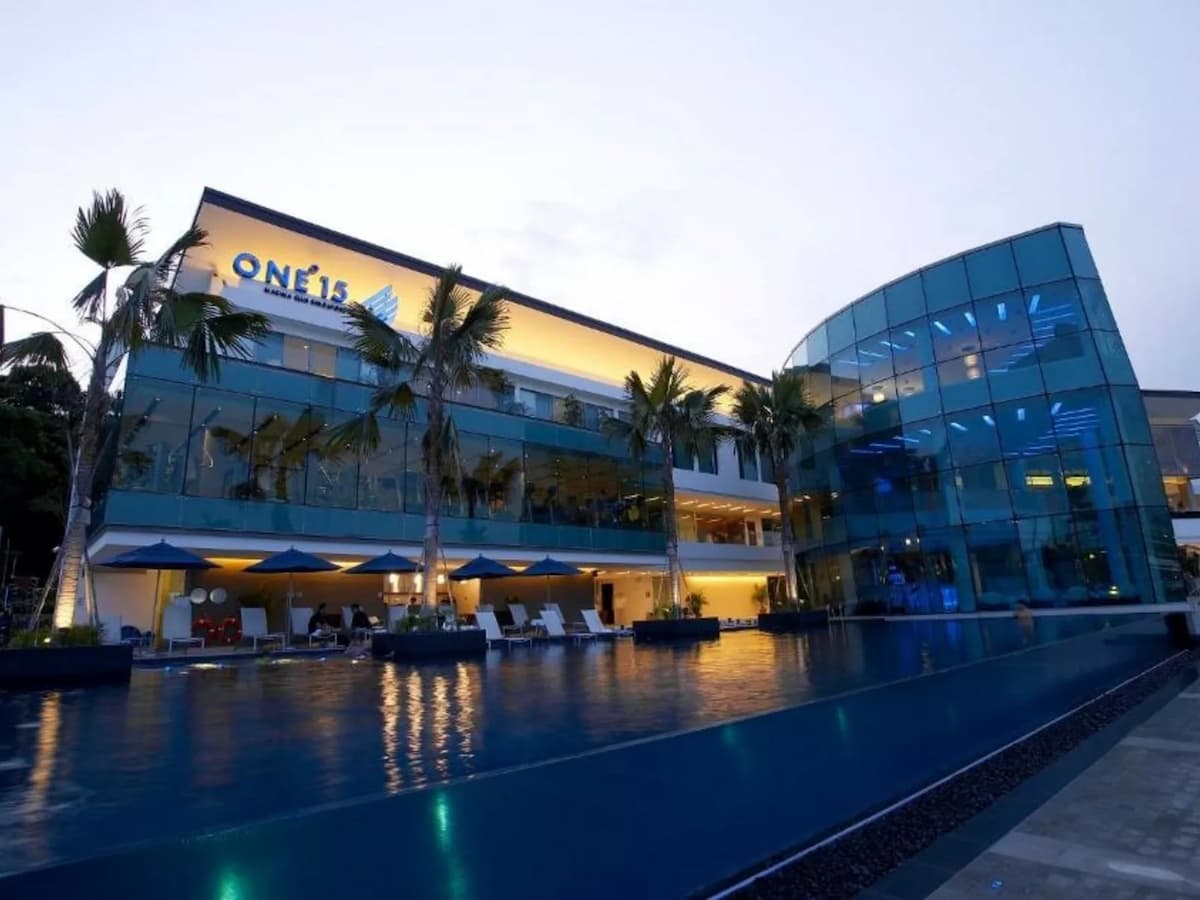 ONE°15 Marina waterfront building with infinity pool at dusk.