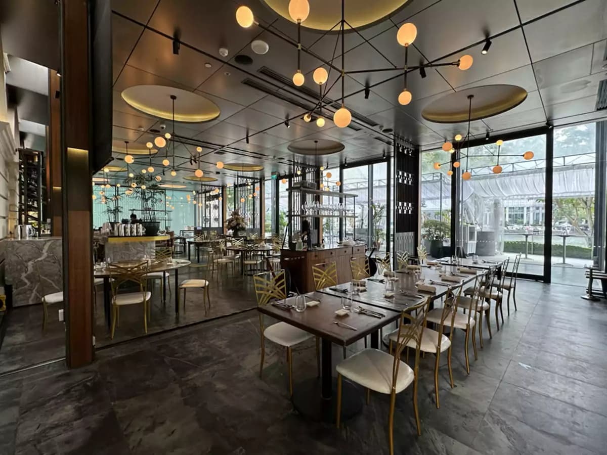 Modern restaurant interior with long dining tables and ambient lighting.