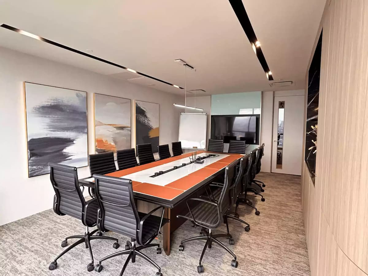 long boardroom table with black chairs and abstract wall art at corporate meeting event venue in kuala lumpur