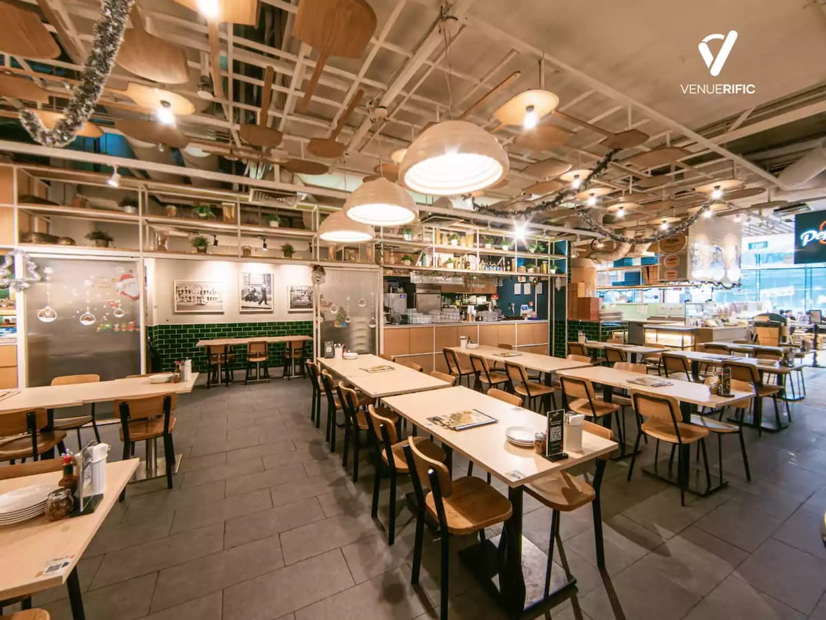 Modern casual dining venue with wooden tables, open ceiling design, and warm ambient lighting.