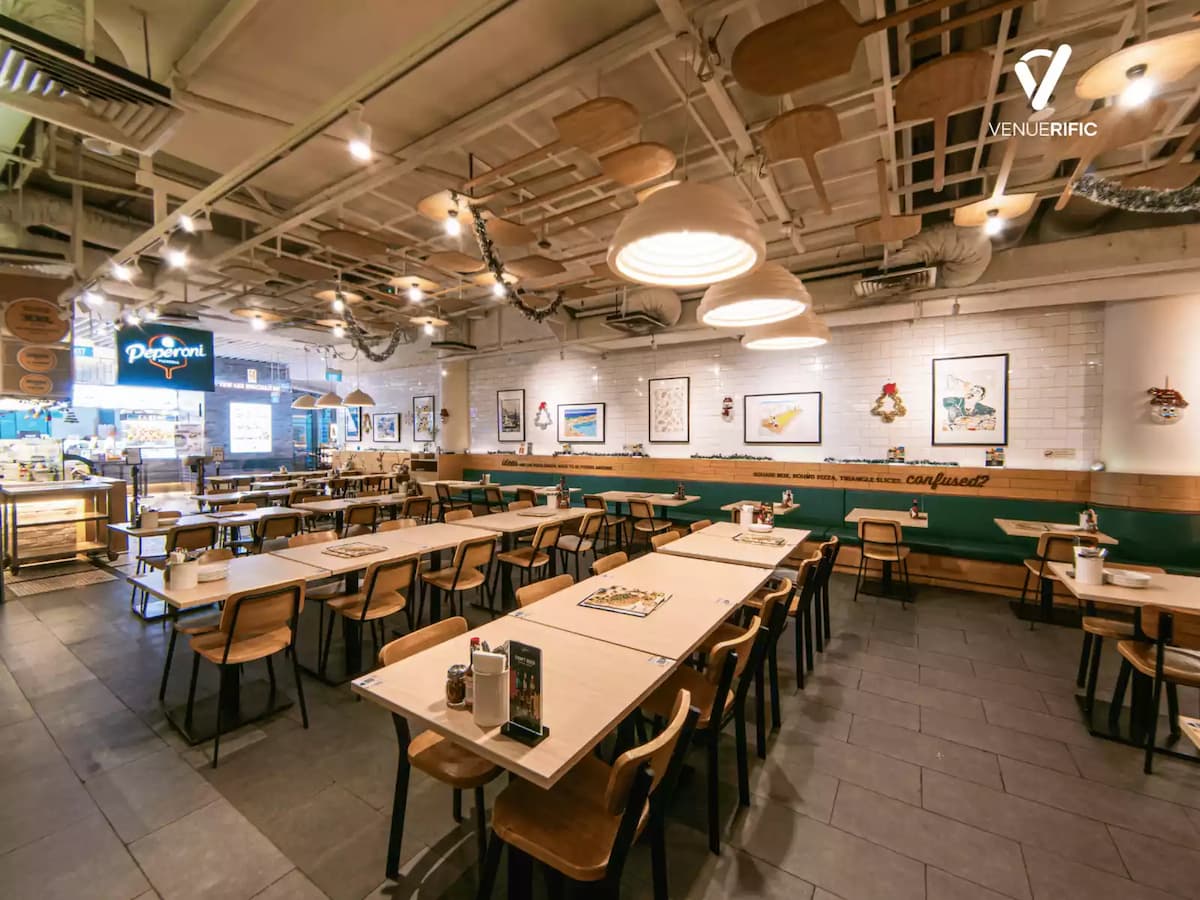 Spacious modern restaurant with wooden tables, warm pendant lighting, and contemporary industrial décor.