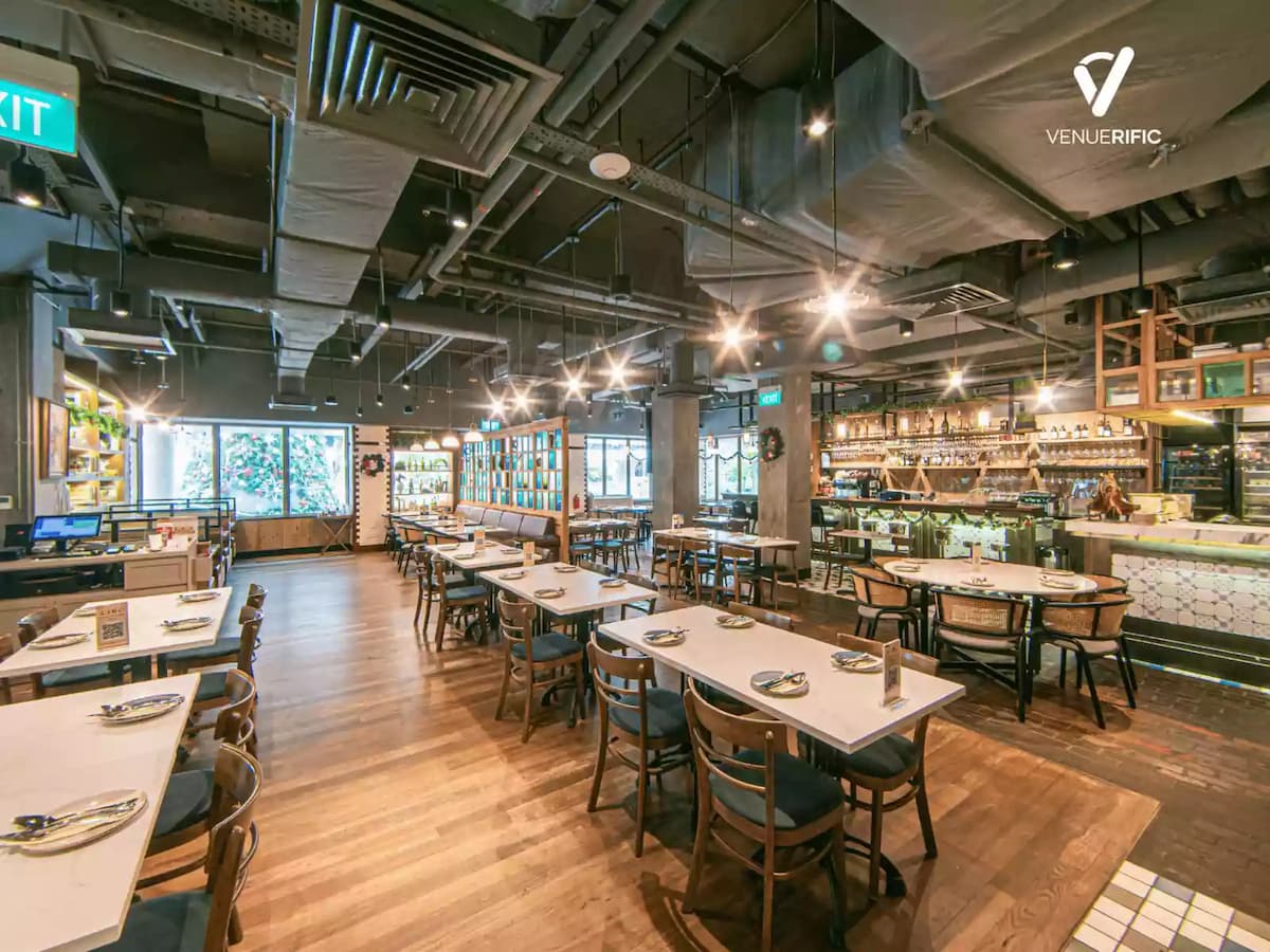 Spacious industrial-style restaurant with wooden tables, open bar, and warm ambient lighting.