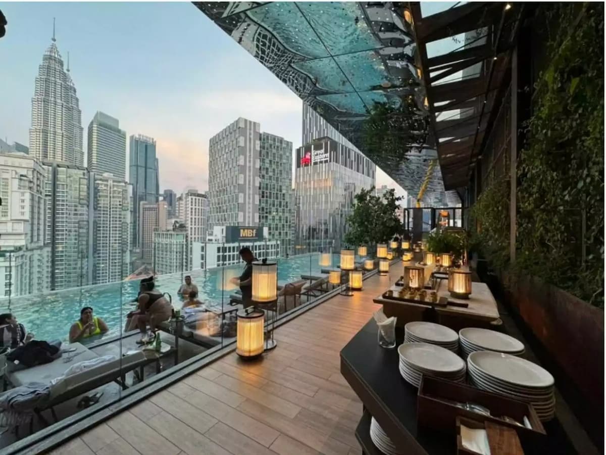 buffet counter on rooftop pool deck overlooking petronas towers at social lounge event venue in kuala lumpur