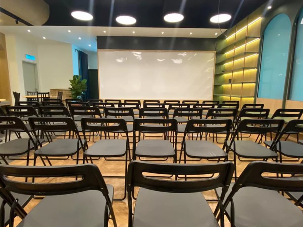 rows of black folding chairs in theatre seating facing a projector screen at event loft seminar venue in seri petaling kuala lumpur