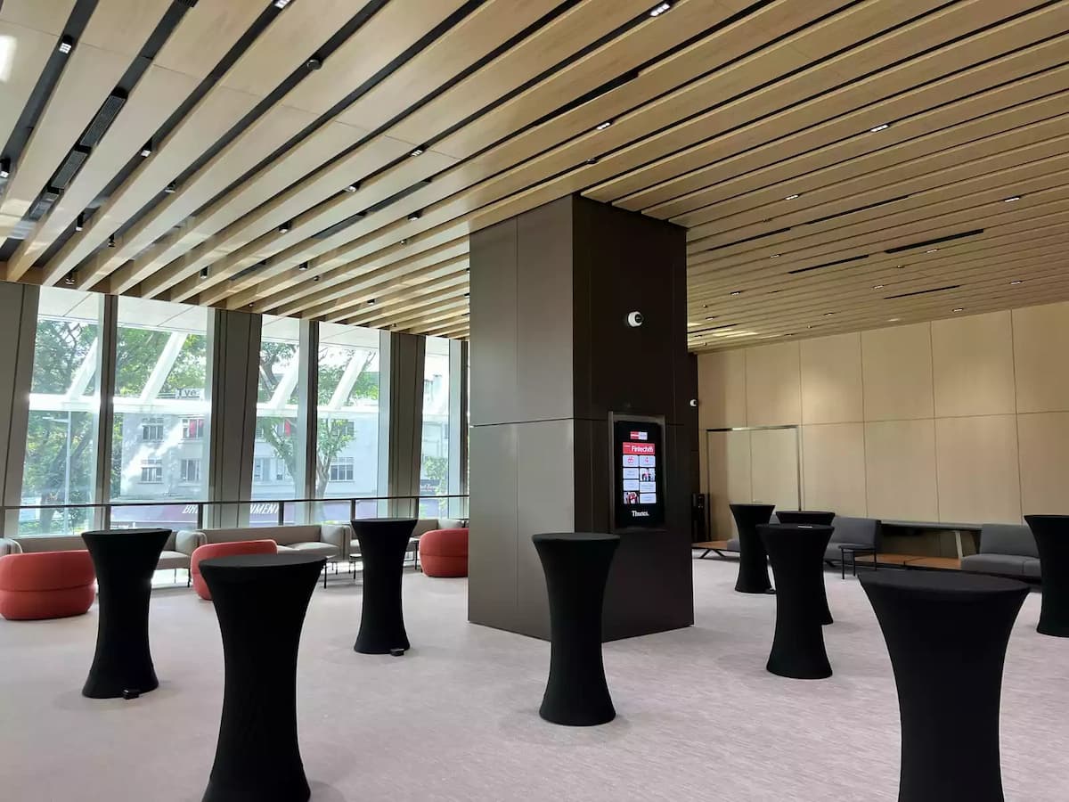 Modern event lounge with cocktail tables and floor-to-ceiling windows.