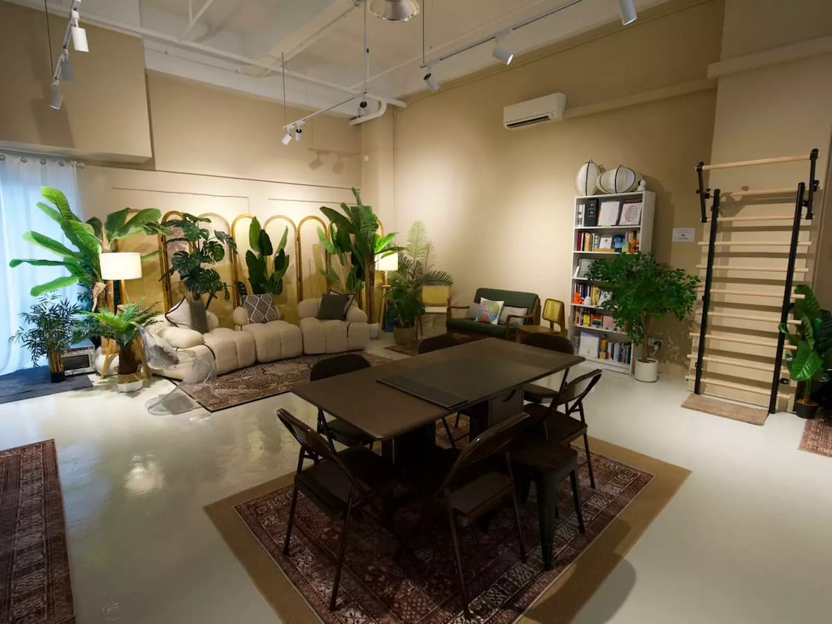 Warm event space with dining setup, lounge seating, and indoor plants.