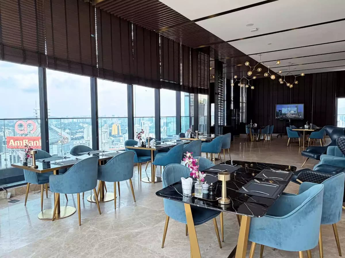 sky dining hall with teal armchairs and floor to ceiling city view windows at an affordable sky lounge event space in kuala lumpur