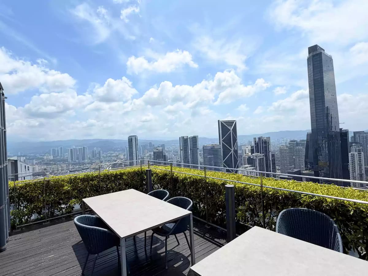 outdoor rooftop terrace with dining tables and kuala lumpur skyline view at a sky lounge event space