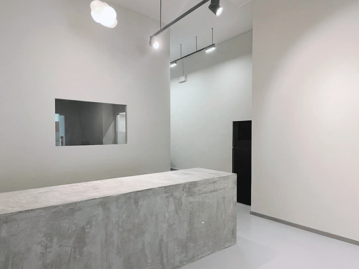 Minimalist space with a concrete counter, white walls, and modern track lighting.