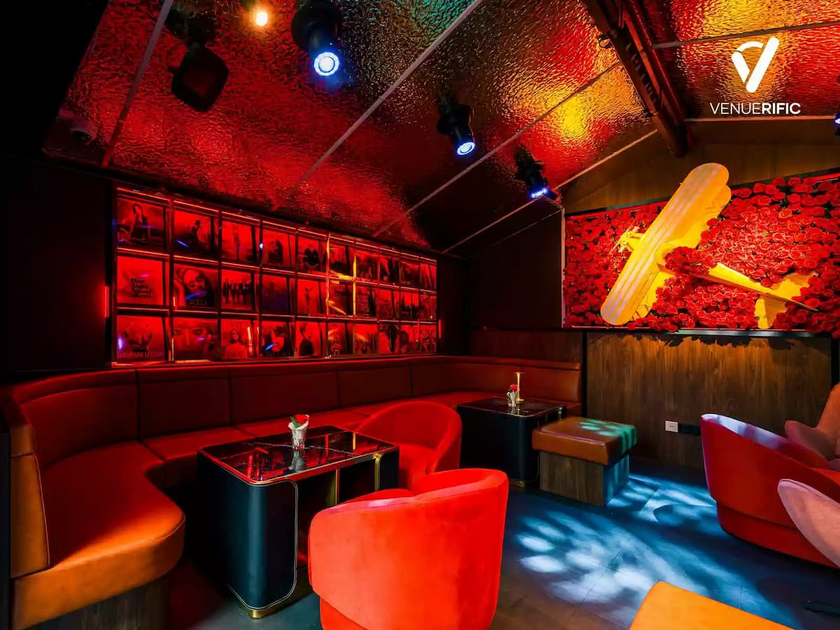 Intimate lounge with red ambient lighting, plush seating, and decorative wall features for a cozy nightlife setting.