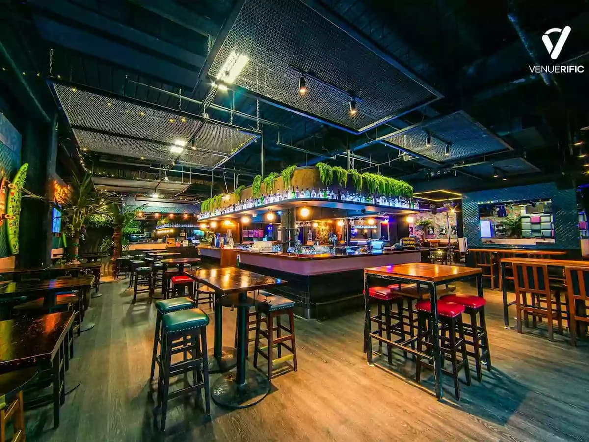 Modern bar lounge with central counter and casual high-table seating.