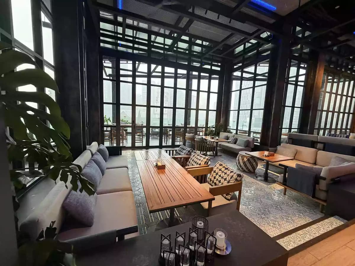 daytime lounge with sofa seating and greenery by tall windows at social lounge meeting event venue in kuala lumpur