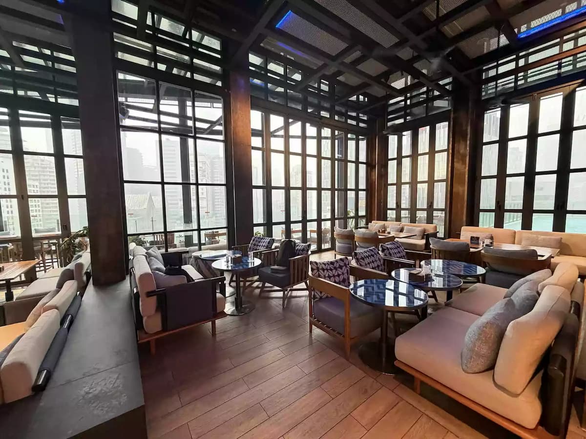 window side lounge seating with armchairs and pool view at social lounge corporate event venue in kuala lumpur