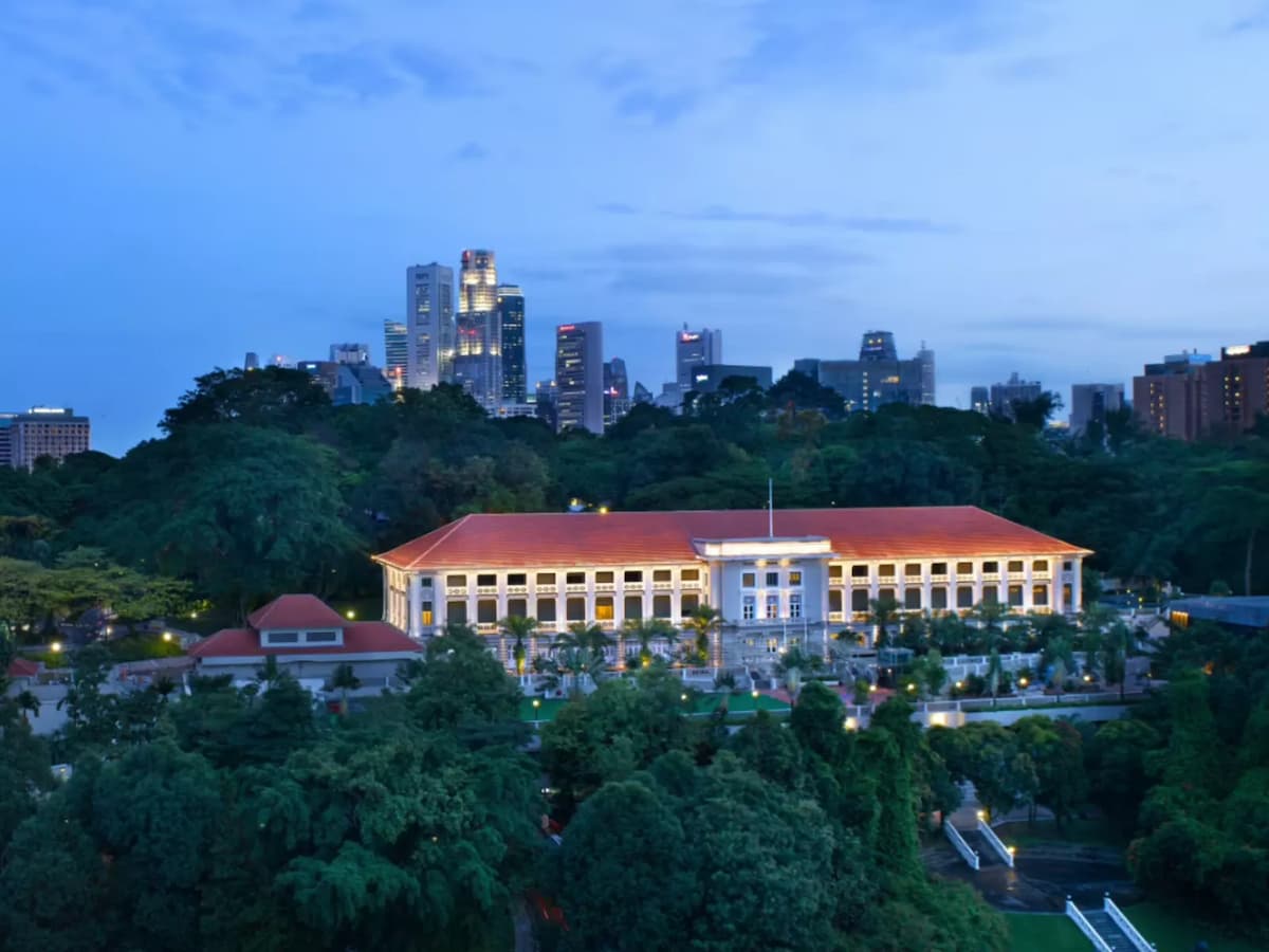 Aerial dusk view of METT Hotel building surrounded by lush greenery