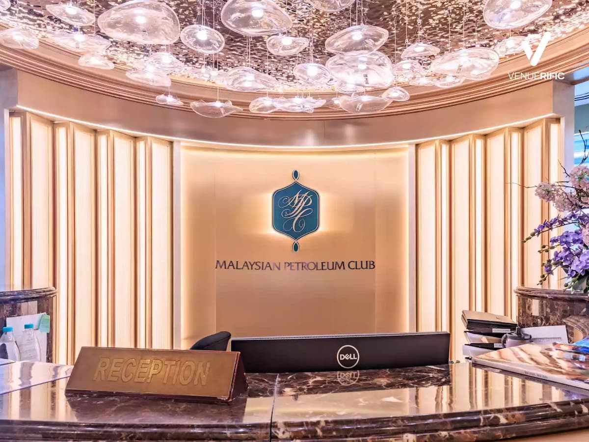 Reception lobby with elegant lighting, marble counter, and Malaysian Petroleum Club signage.