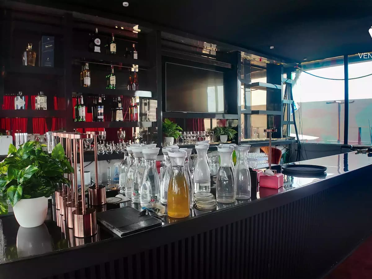 full service bar counter with spirit bottles glassware and water carafes at a cocktail event venue in petaling jaya
