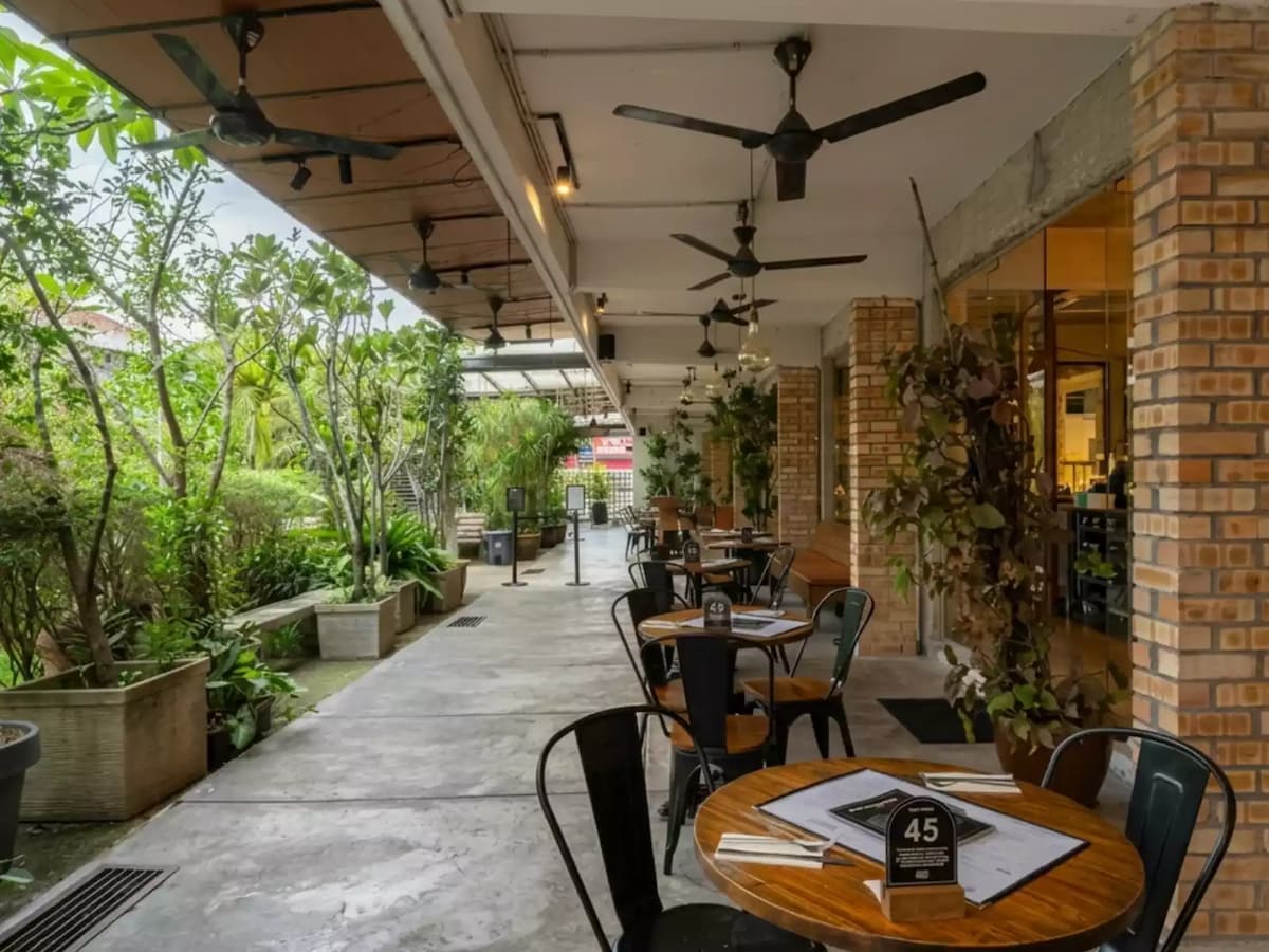 Garden terrace with outdoor café seating, lush greenery, and a relaxed alfresco setting for casual dining and private events.