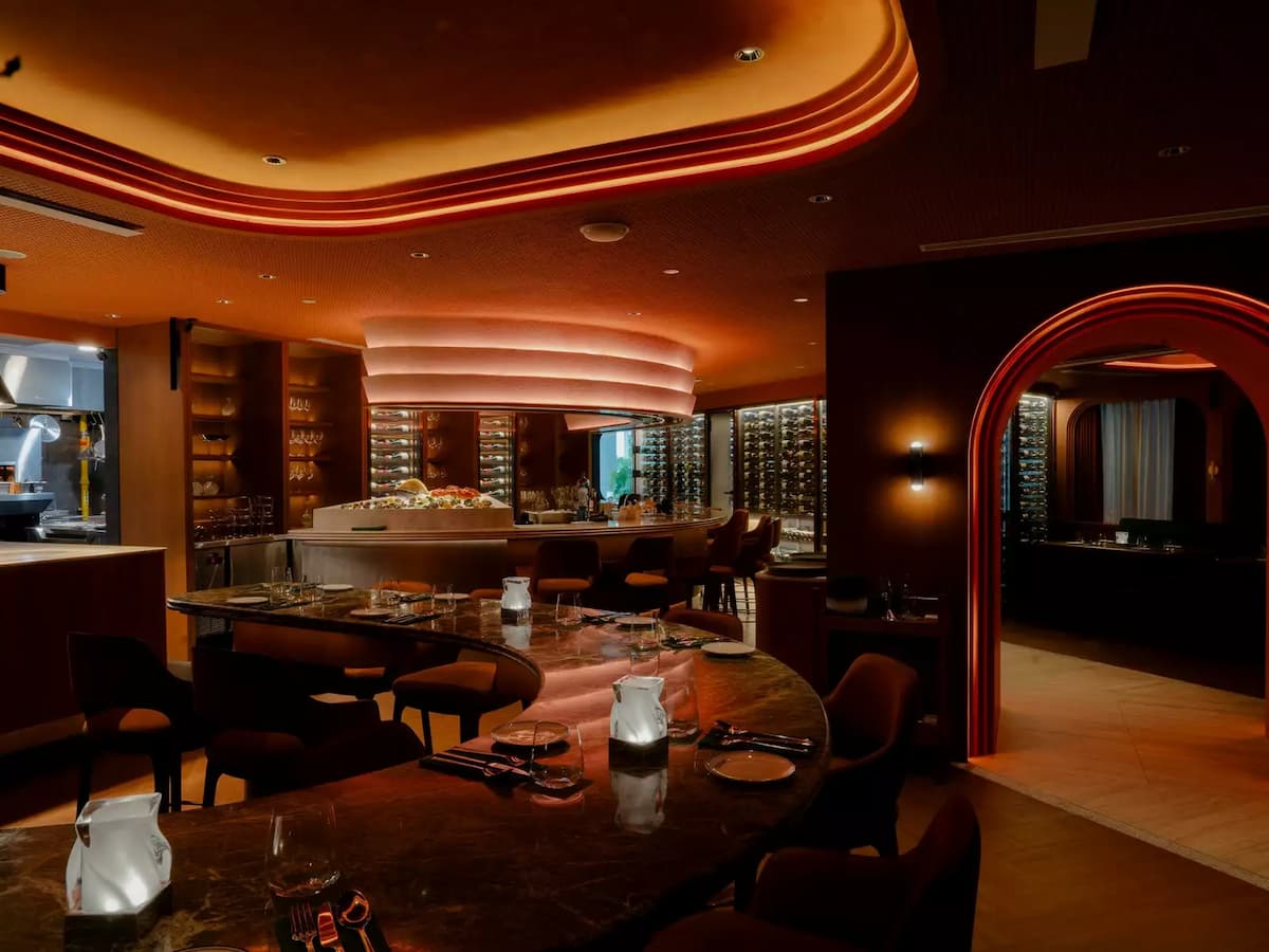warm lit private dining room with curved marble tables at temper wine room event venue in tanjong pagar singapore