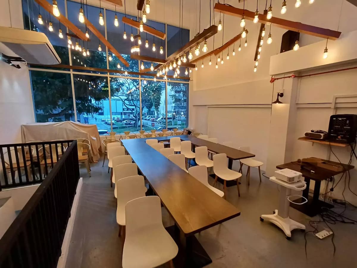 long table seating with pendant edison bulbs by the window at the upper room meeting event space in singapore