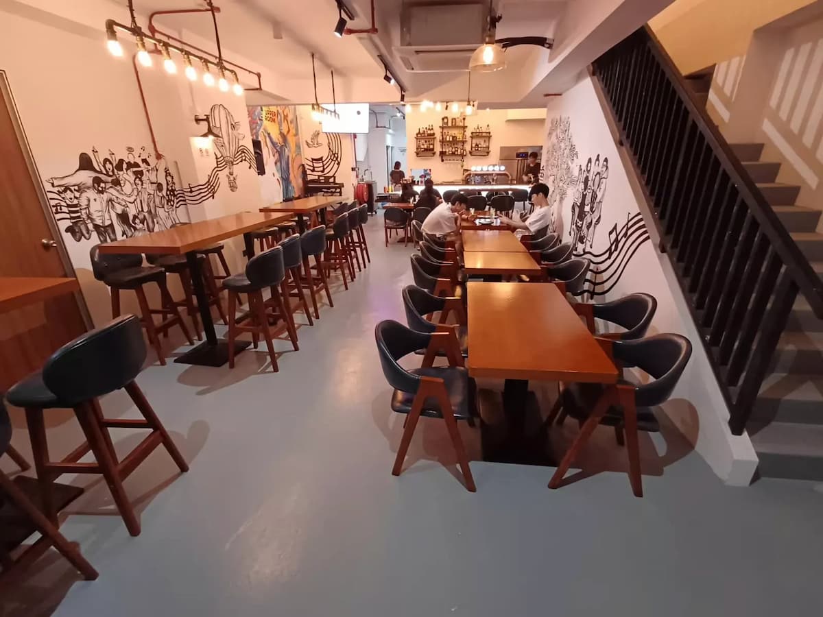 communal wooden dining tables and bar stools at the upper room cafe event venue in singapore