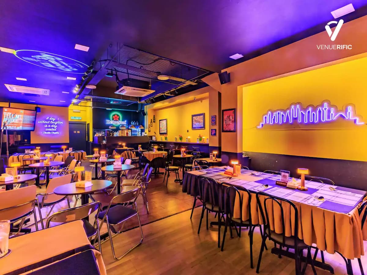 long dinner table set with candles in front of a neon city skyline mural at a private dinner event venue in bandar sunway