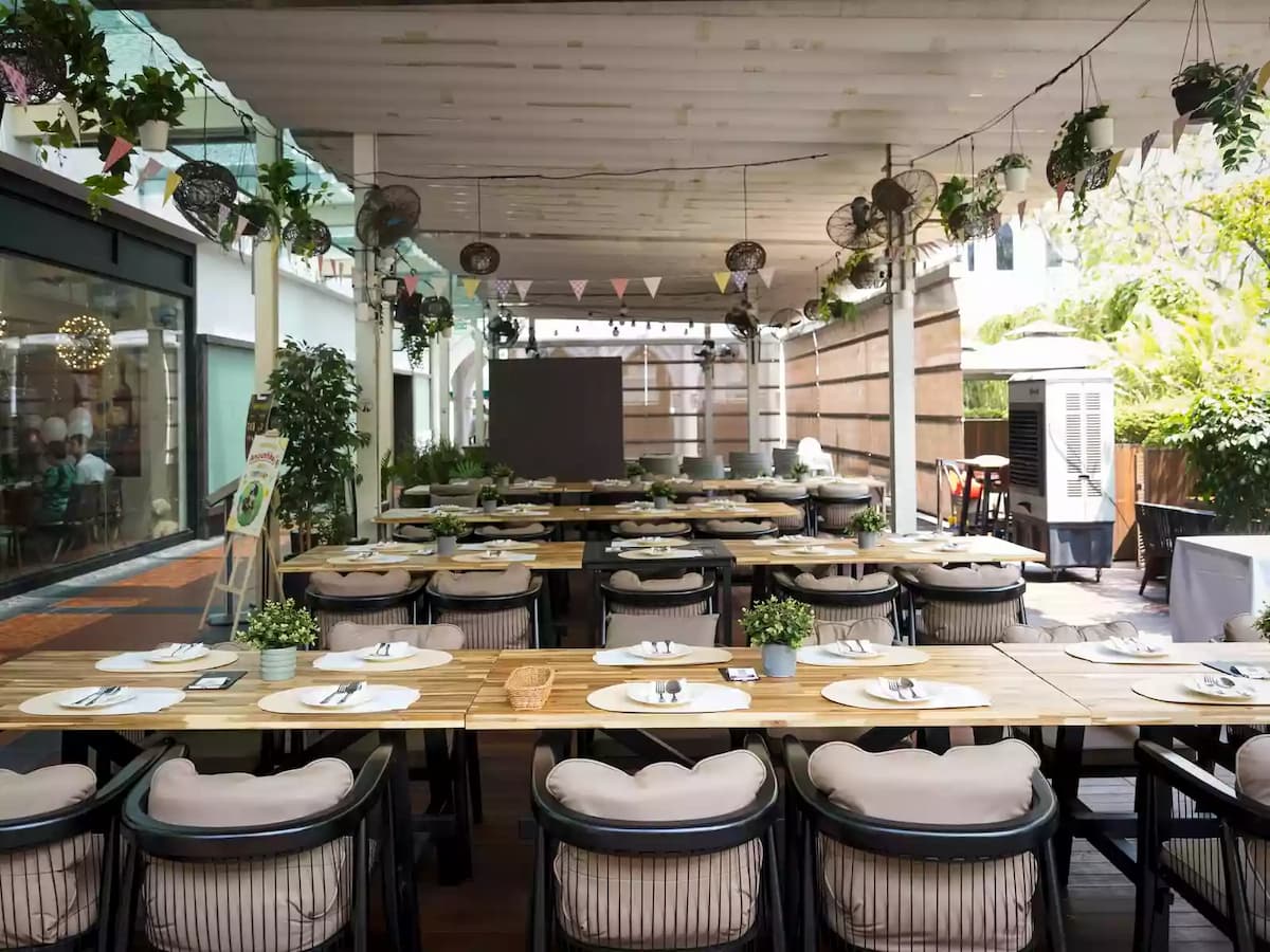 outdoor dining event space with long tables and greenery at lebua thai in chijmes singapore