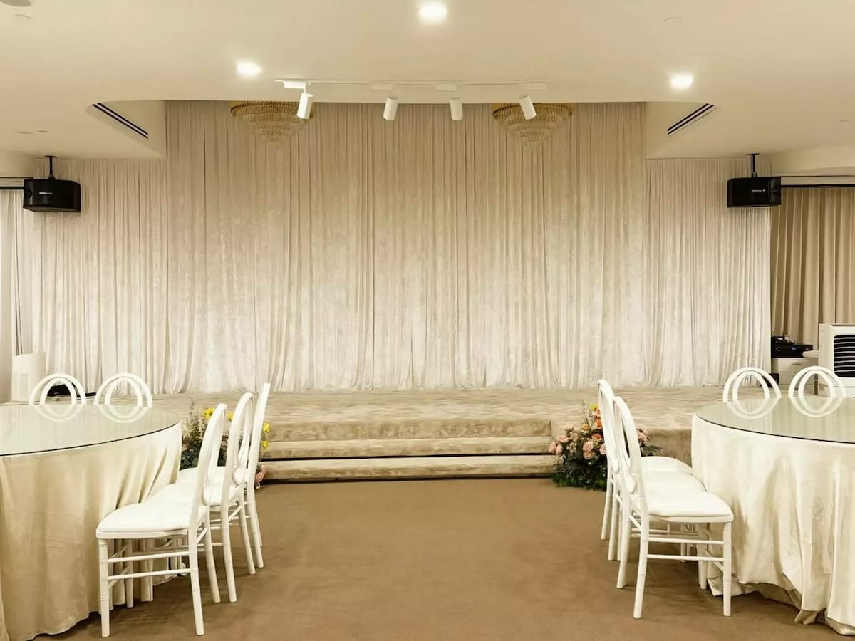 banquet tables and chairs facing an indoor stage at ivory by pu3 event space in somerset singapore