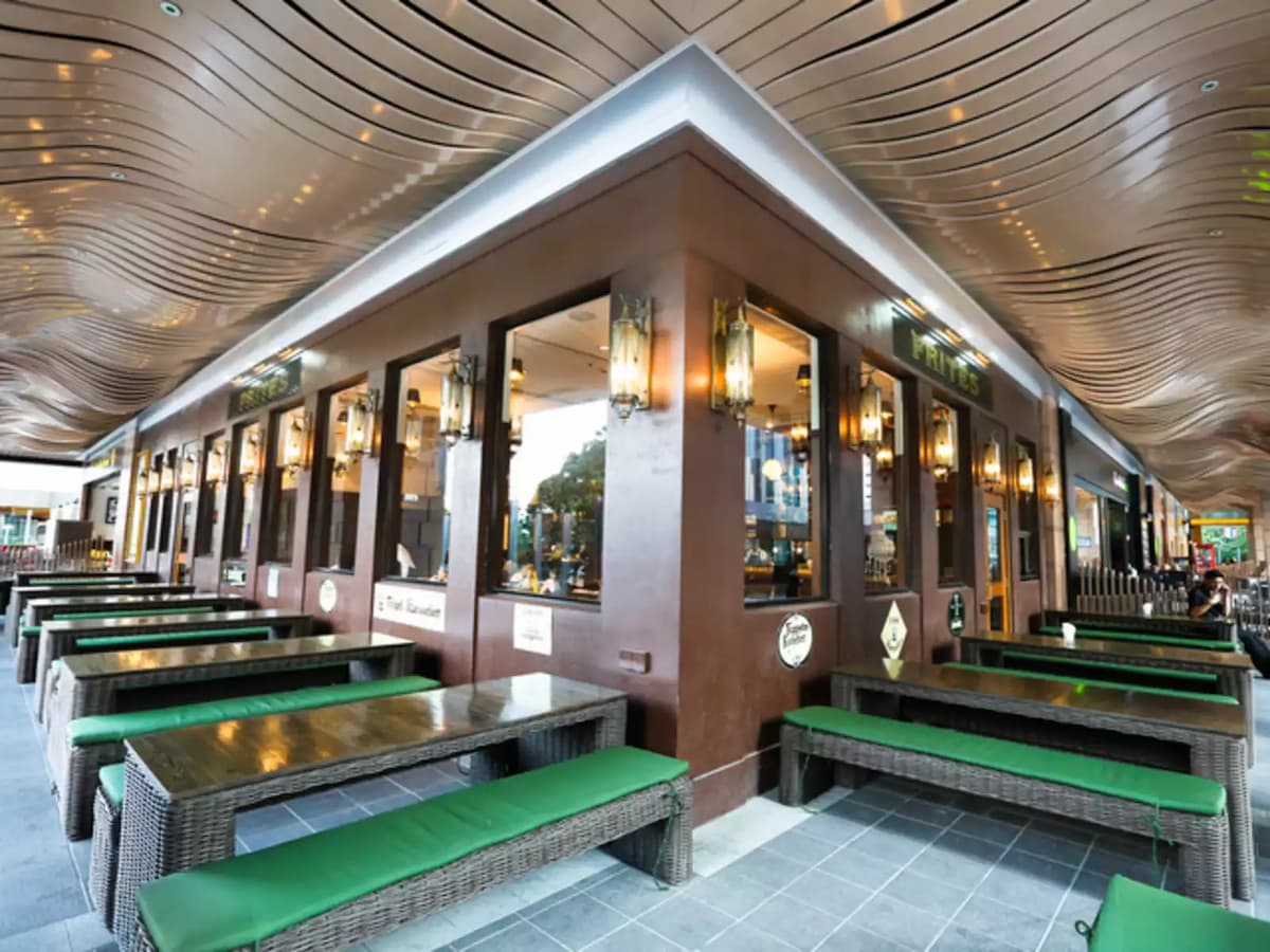 outdoor event space area with long table and chairs covered with green cushion