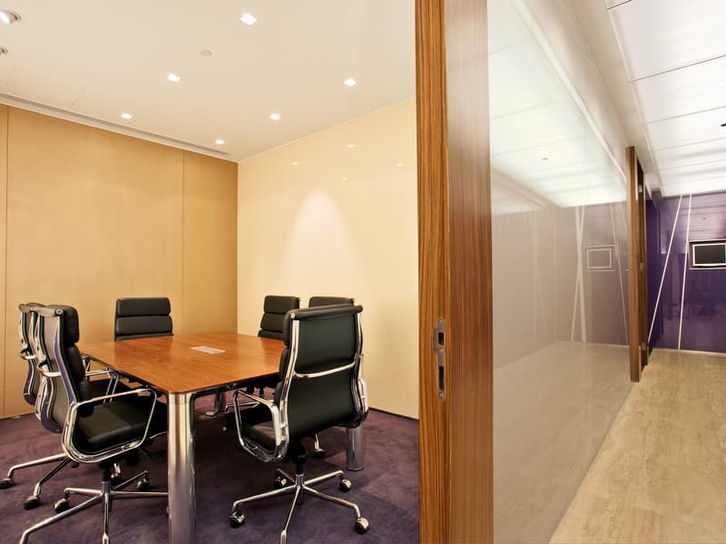 small meeting room using purple carpet and equipped with table chairs