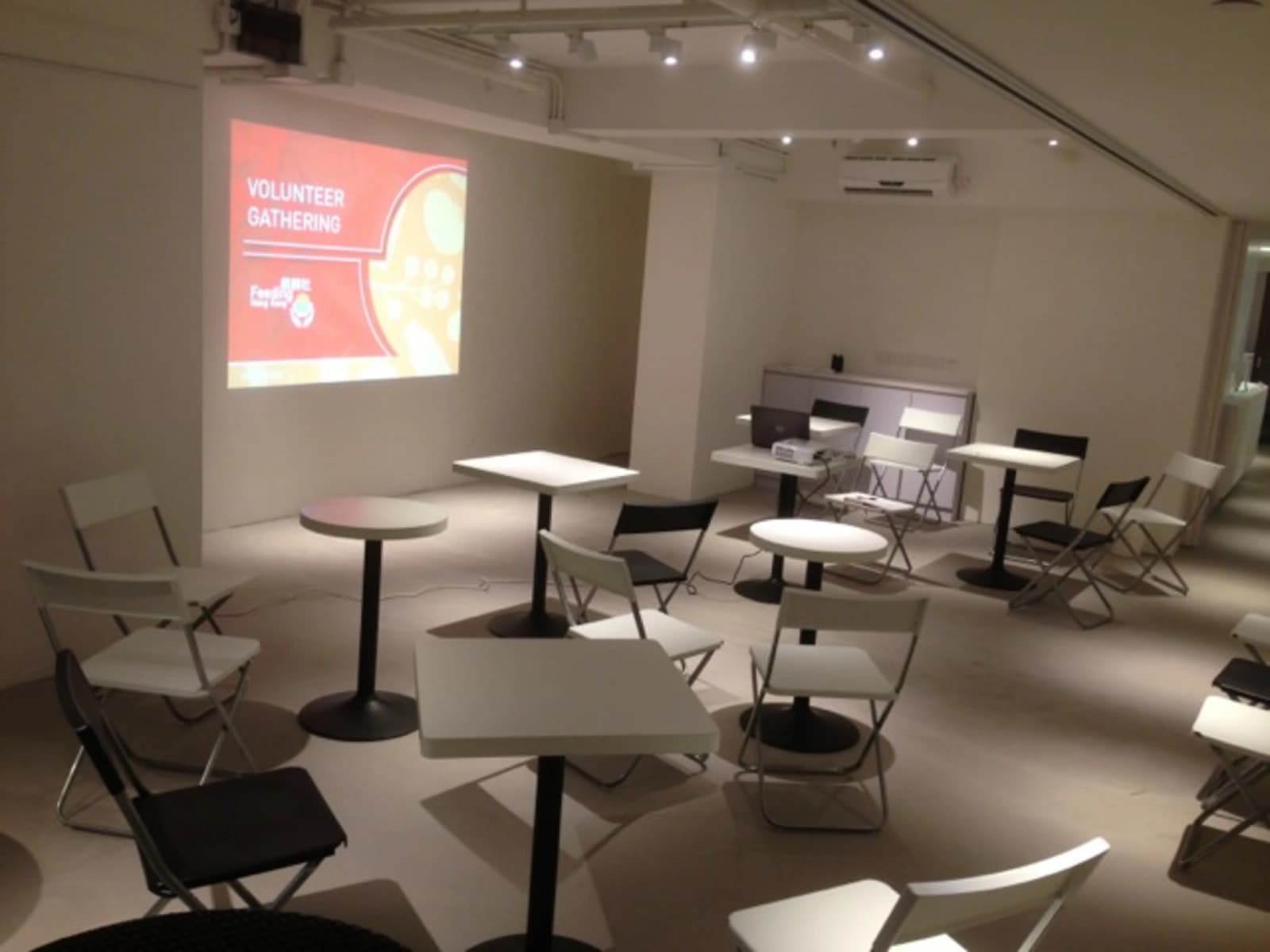 small tables for breakout sessions equipped with projector screen in event space
