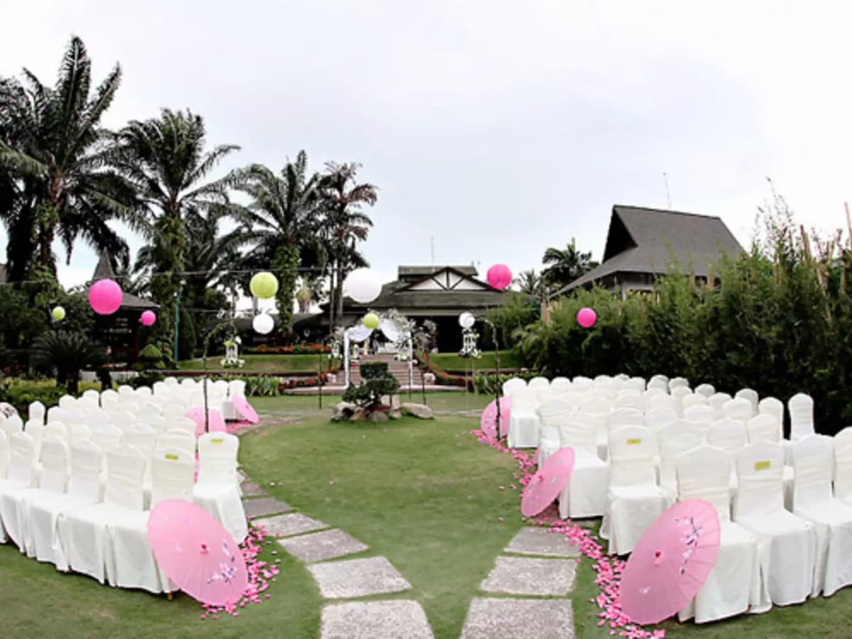 outdoor solemnisation decorate with white chairs and pink ballons