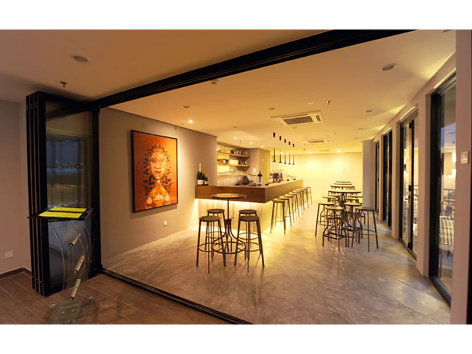 bar with 130 capacity with yellow lighting and glass door