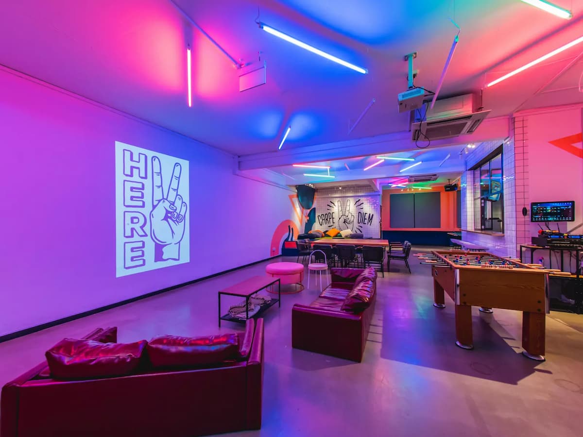 graduation party event venue for rent with foosball table and leather couches facing a white projector wall