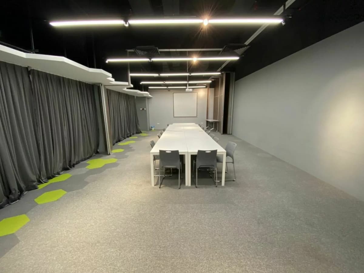 offsite meeting event venue with conference table in large grey room with grey curtains
