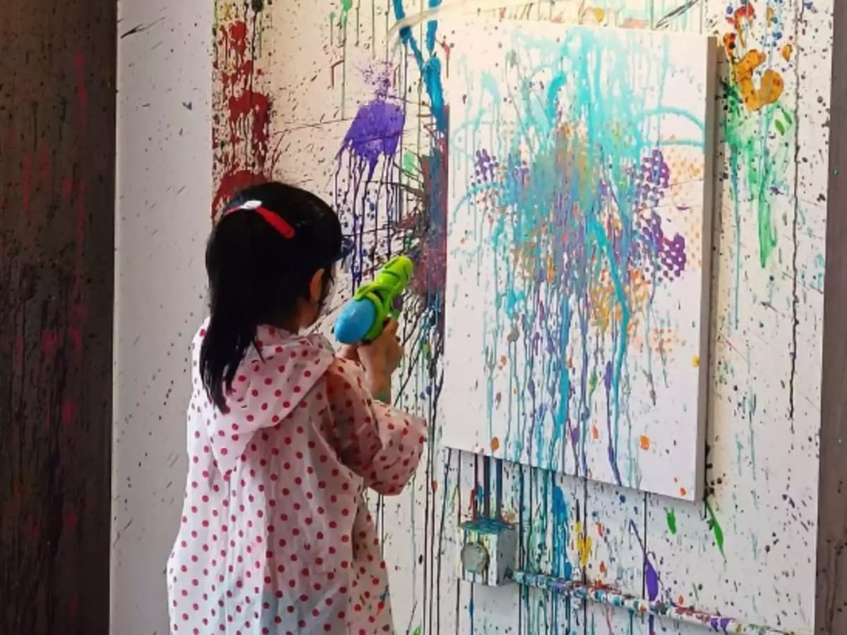 child splattering paint on a wall
