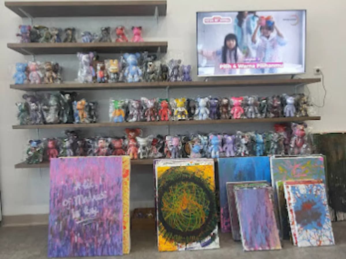 colorful paintings on a floor while bear toys are painted behind them