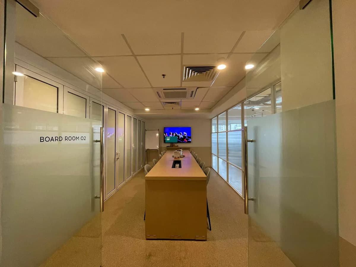 board room with long wooden table and TV
