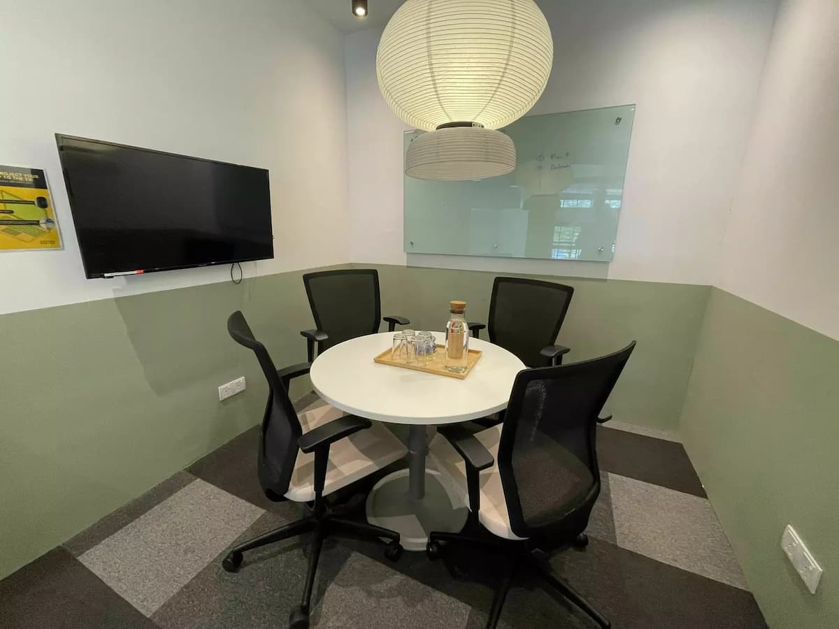 small meeting room with table and chairs and screen