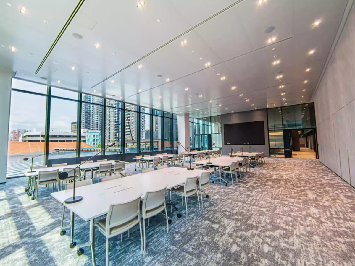 spacious room with high ceiling and white tables and chairs