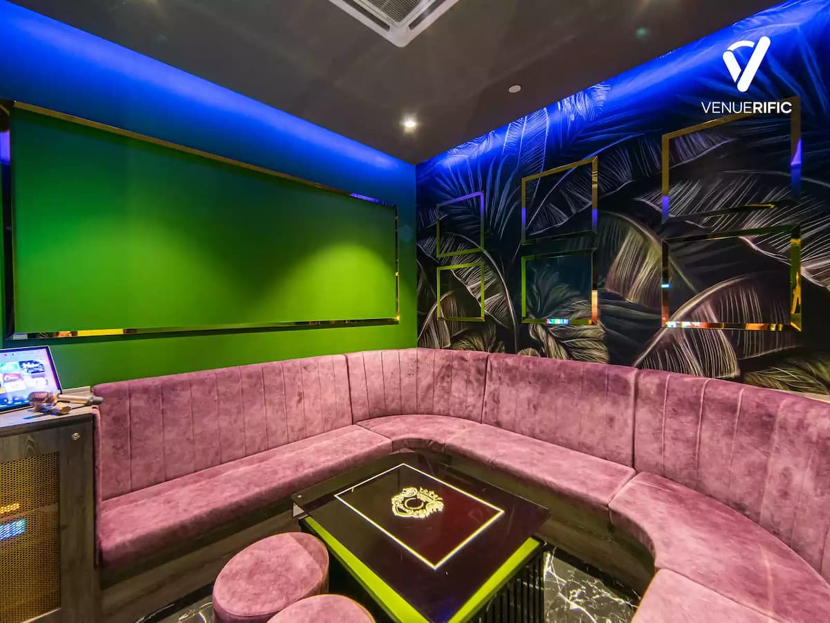 small karaoke room with pink velvet u shaped couch