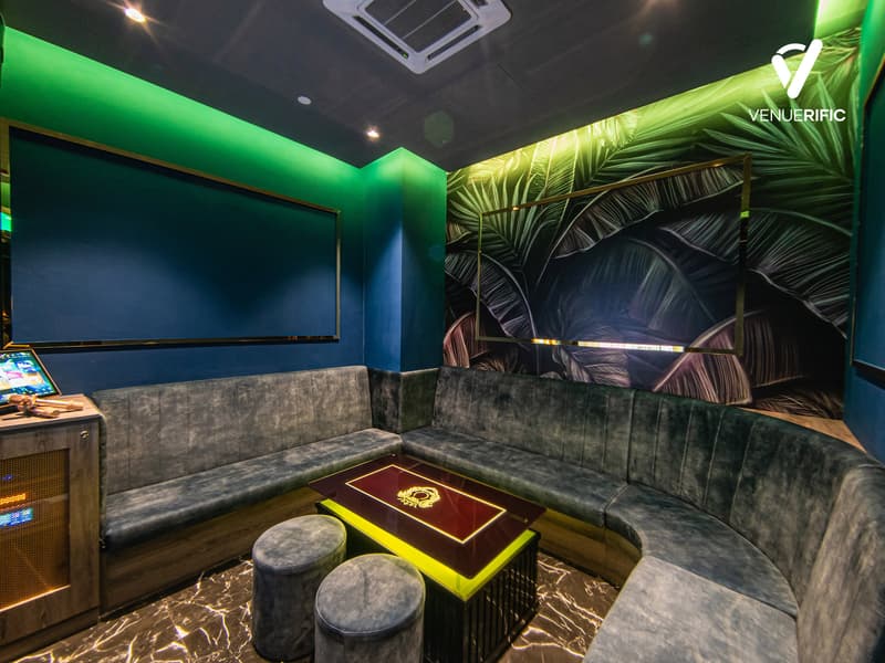 small ktv room with u shaped gray velvet couch and a center table