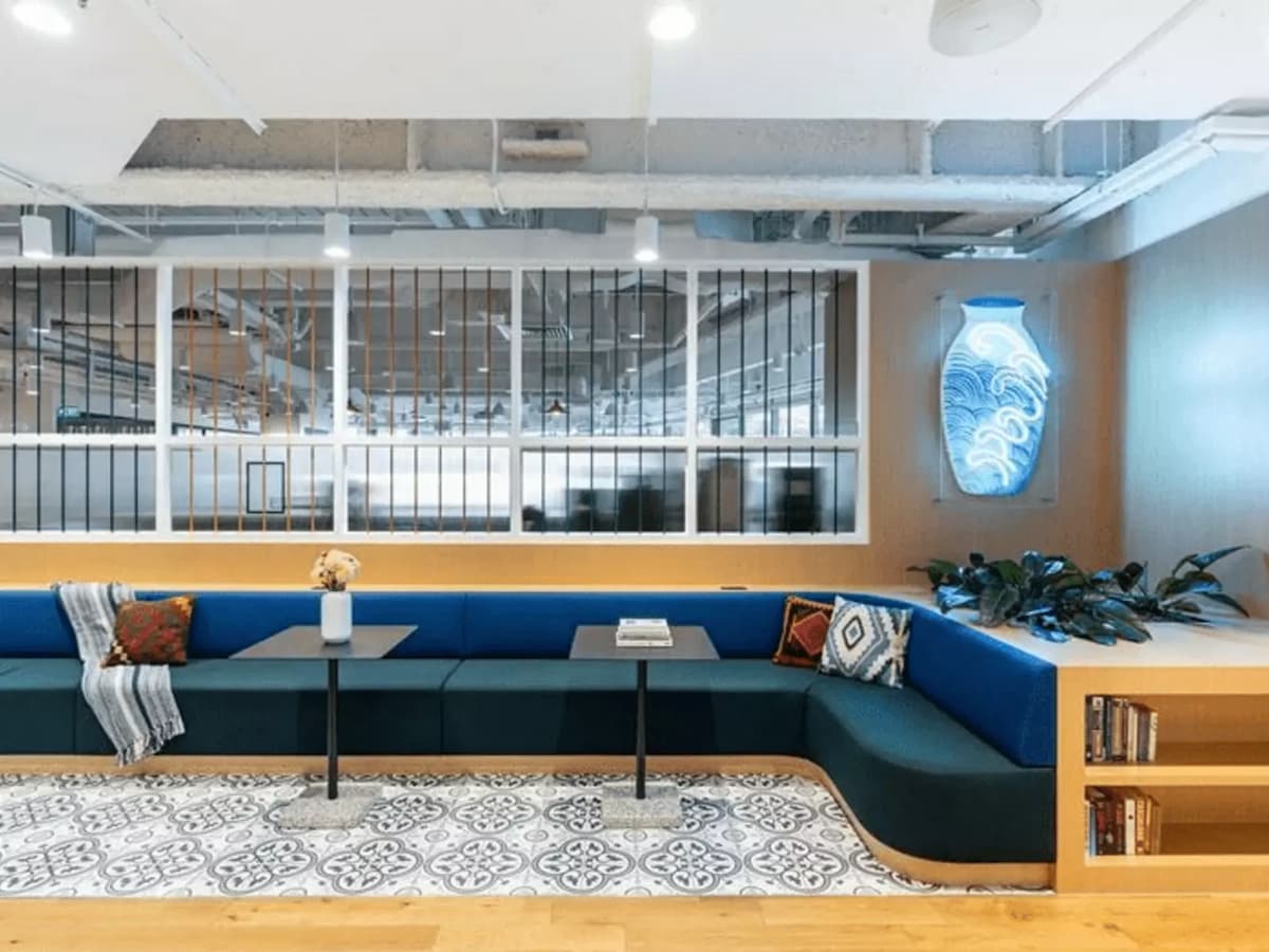 long blue couch with lounges and neon decor
