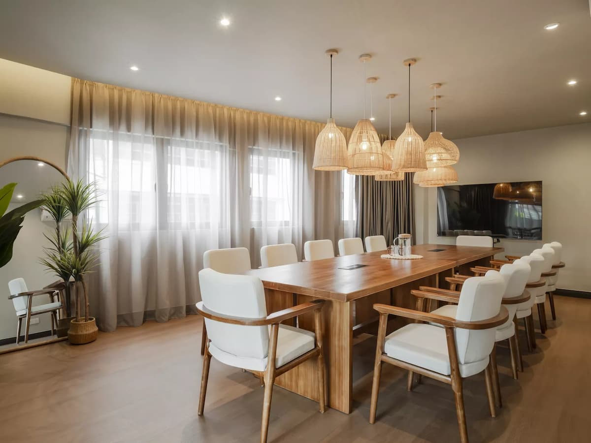 minimalist and elegant meeting room with a large wooden table, comfortable white chairs and sheer curtains